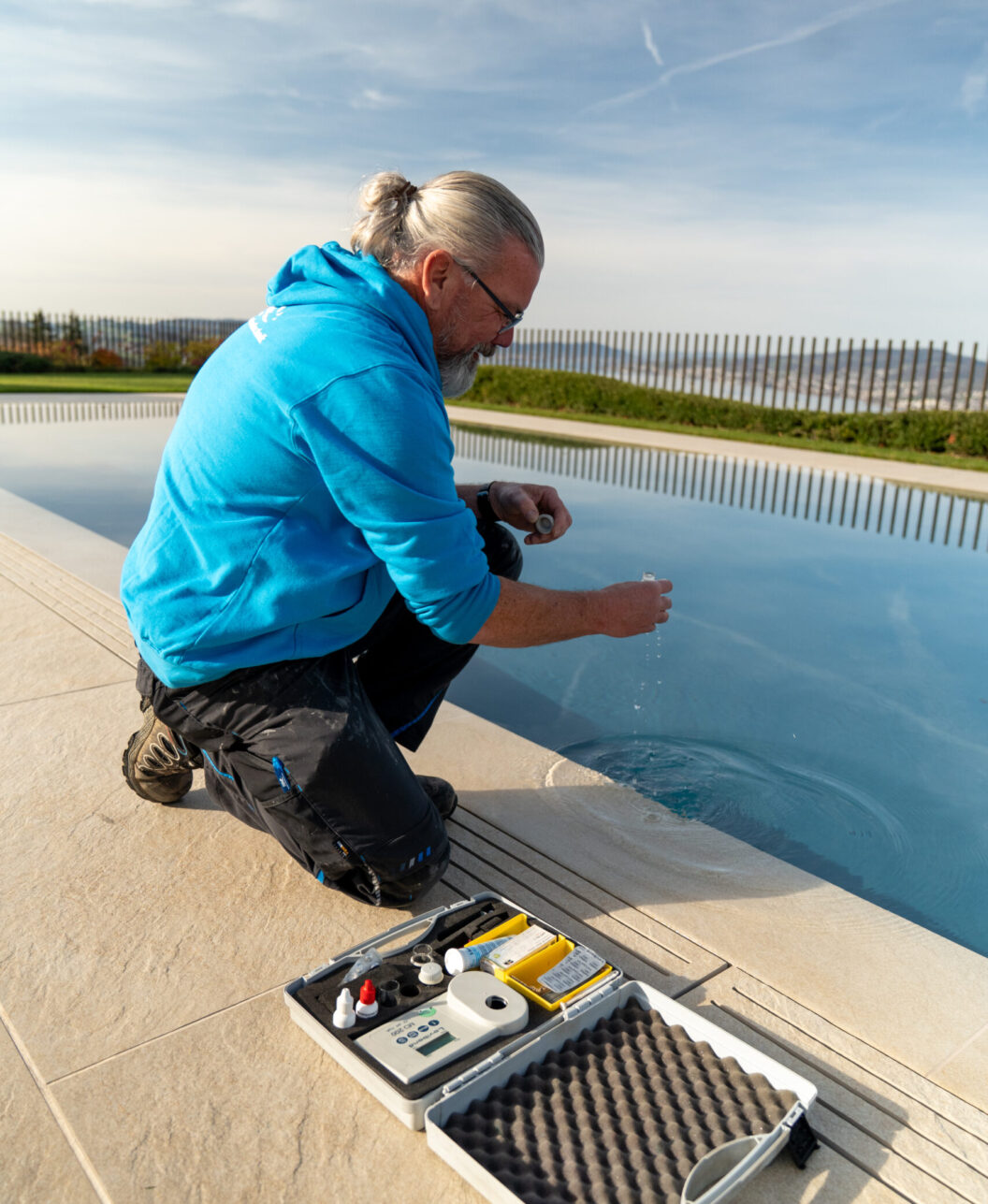 Woodtli-Servicetechniker prüft die Wasserwerte am Beckenrand