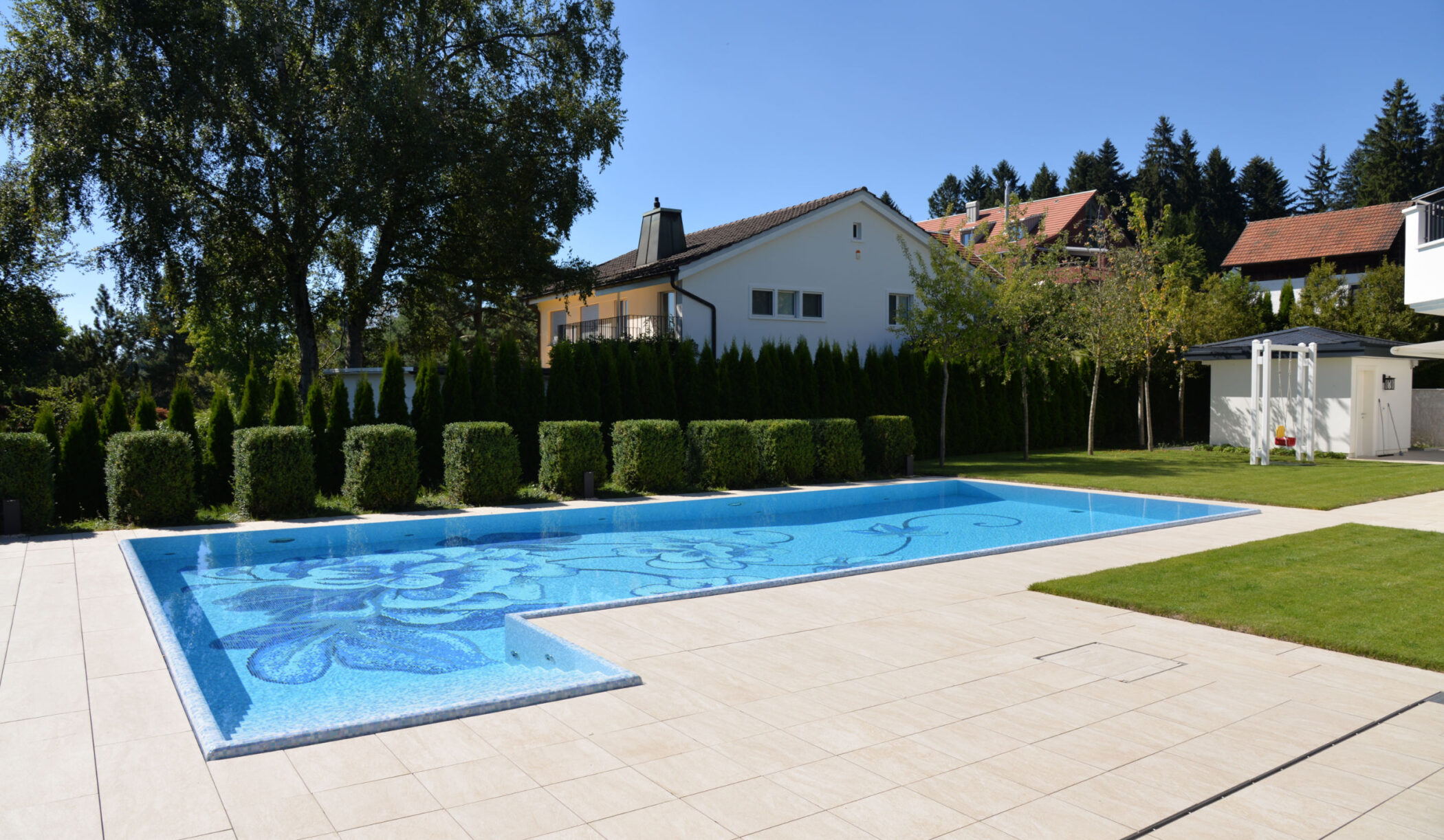 Garten-Schwimmbad mit allseitiger Überlaufrinne und Mosaik ausgekleidet, Zumikon