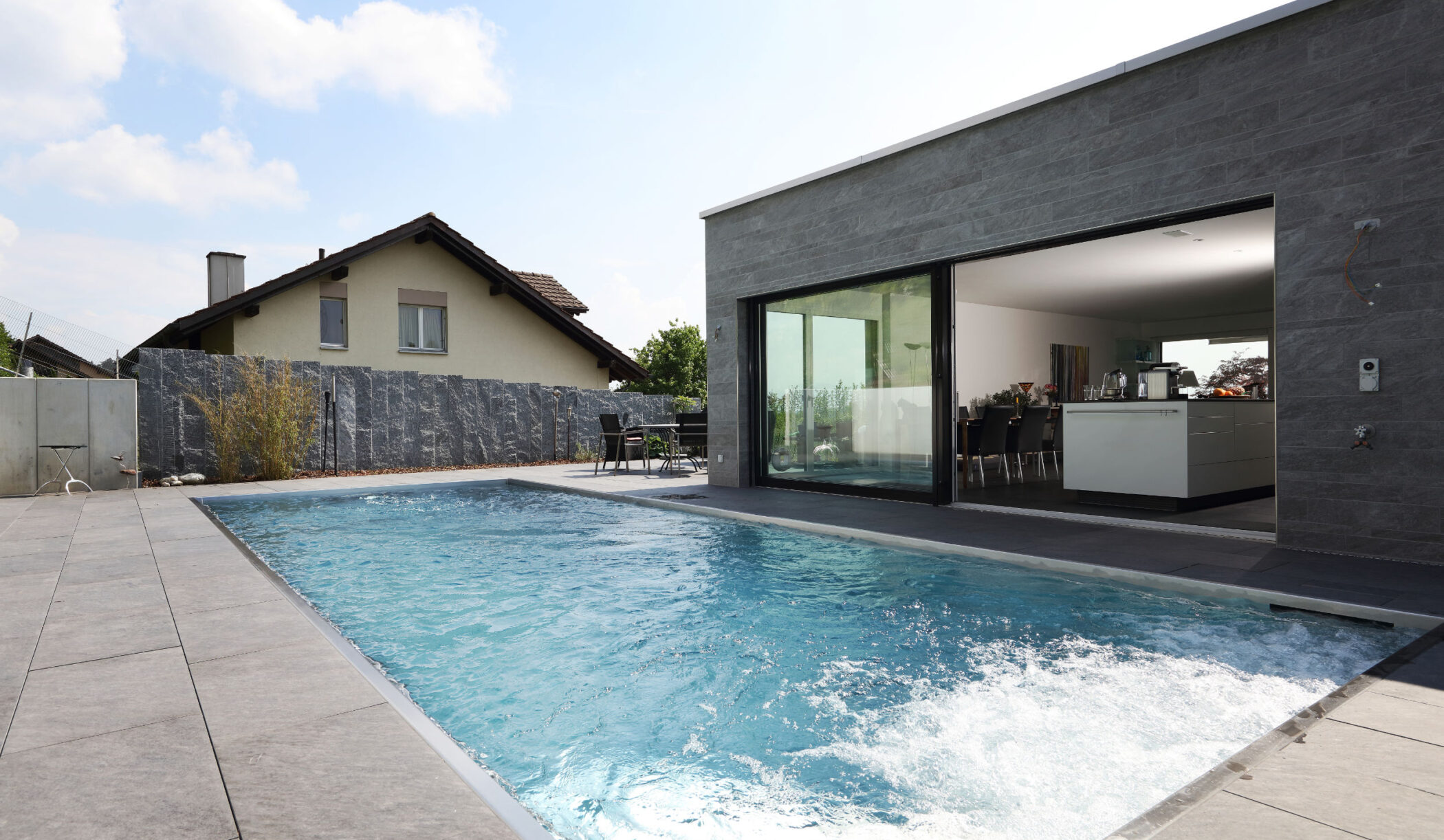 Edelstahl-Schwimmbecken neben Terrassenhaus, Grüt