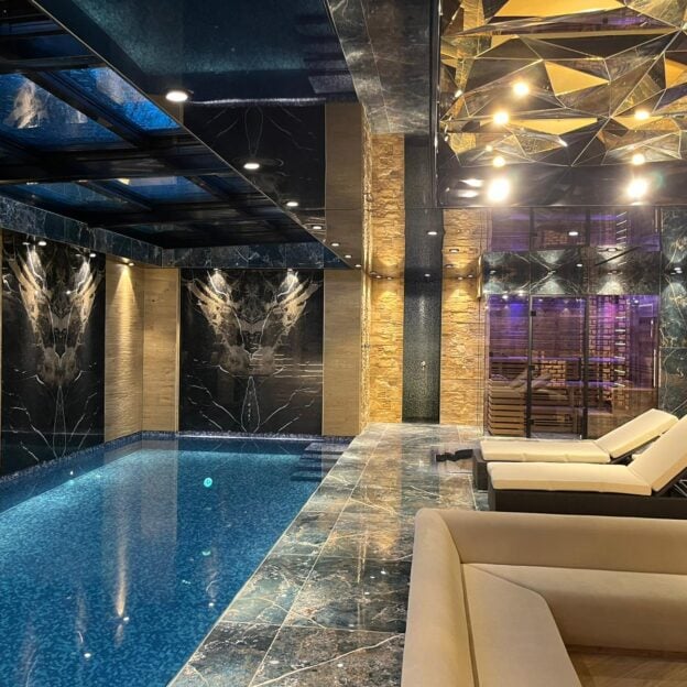 Prämiertes privates Hallenbad mit dunklem Naturstein und Lichtdesign, bsw-Award 2024 Silber