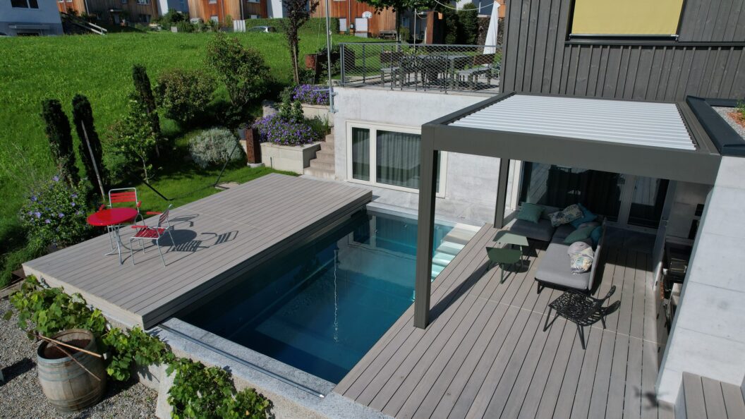 Schiebedeck halb geöffnet über einem Pool mit Blick auf die Terrasse