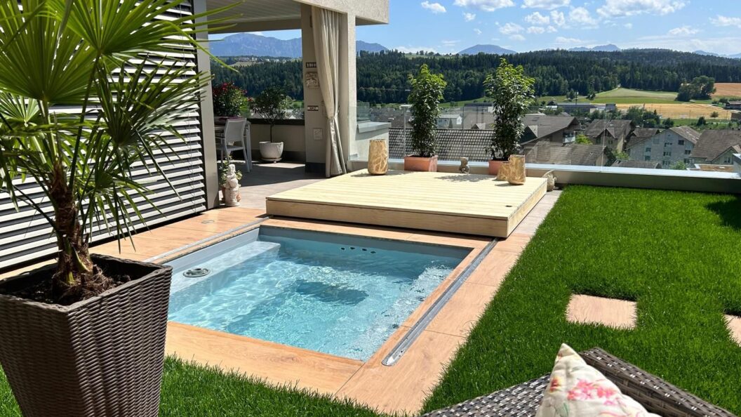 Kleiner Pool mit zur Seite geschobenem Schiebedeck auf einer Dachterrasse