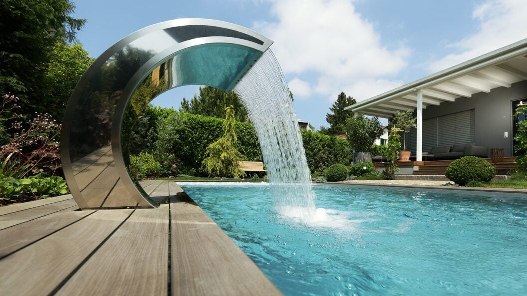 Wasserschwall aus gebogenem Edelstahl an einem Pool