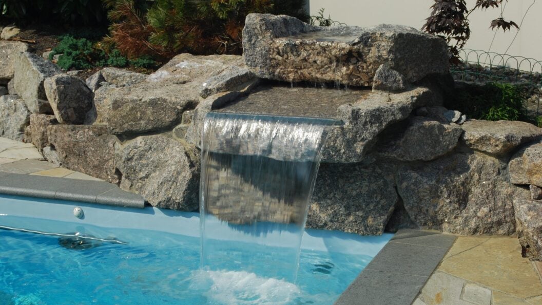 Wasserfall über Natursteine an einem Folienpool in Bünzen