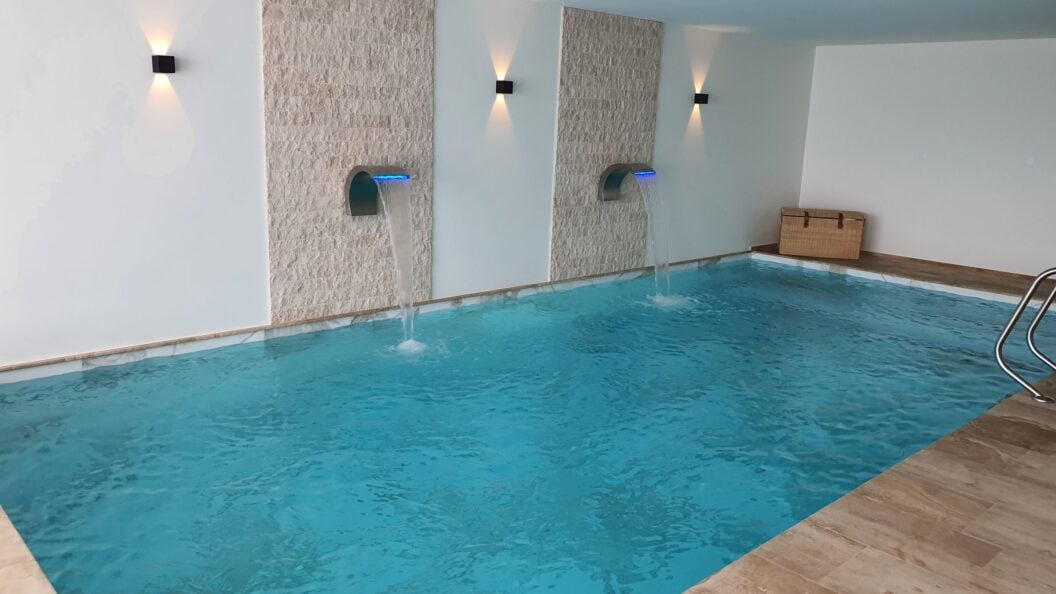 Hallenbad mit zwei Wasserschwallen aus der Wand